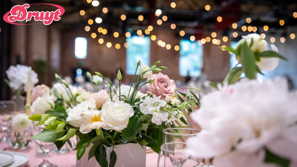 A detailed view of floral arrangements at a wedding reception, with soft lighting in the background. Can you get invited to a wedding? It largely depends on your relationship with the couple and the formality of the event.